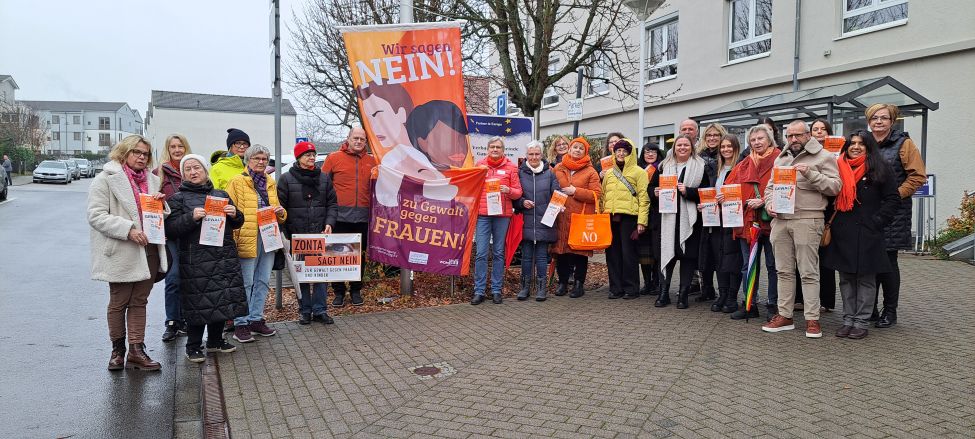 Zu sehen ist ein Gruppenfoto mit den Beteiligten bei der Fahnenhissung anlässlich des Internationalen Tages gegen Gewalt an Frauen und Mädchen